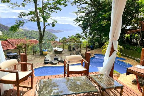 un patio con tavolo, sedie e piscina di Pousada Sonho Real ad Angra dos Reis