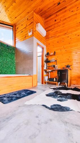 a room with a wooden wall with a large window at Sand River - Cabanas com românticas hidromassagem entre Urubici e Urupema in Rio Rufino