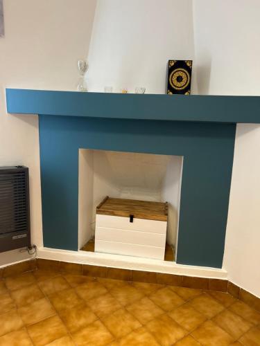 a fireplace with a blue mantle and a clock on top at La Legal EQS in Esquel