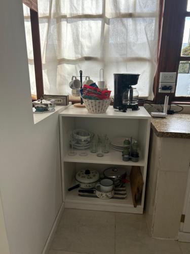 un comptoir de cuisine avec une armoire remplie de vaisselle dans l'établissement La Legal EQS, à Esquel