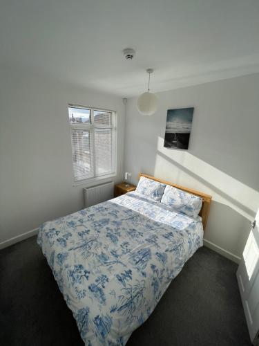 a bedroom with a bed with a blue and white comforter at Nunnery lane 3 bedroom house in York