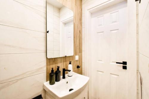 a white bathroom with a sink and a mirror at 1bdr Luxury Suit Prime Location Panorama Ac in Sofia
