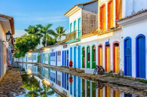 een groep gebouwen met kleurrijke ramen op een straat bij Eco Cabana a 150 metros da praia e centrinho in Paraty