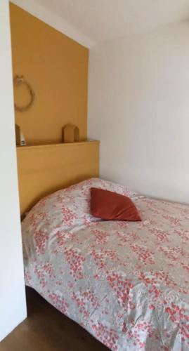 una camera da letto con un cuscino rosso di Chambre et salle de bain privatives a Bénesse-Maremne
