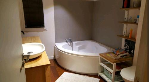 bagno con ampia vasca e lavandino di Chambre et salle de bain privatives a Bénesse-Maremne