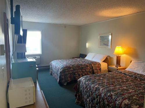 een hotelkamer met 2 bedden en een raam bij Blackstone Hotel in Mandan