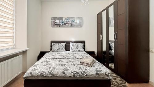 sypialnia z łóżkiem i dużym lustrem w obiekcie Tourist Apart Central Street in Chisinau w Kiszyniowie