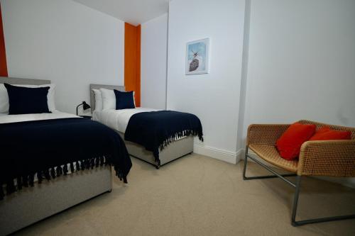 una habitación de hotel con 2 camas y una silla en Spacious two-bedrooms house, private parking, contractors, relocators en Oxford