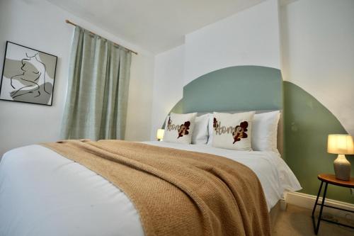 a bedroom with a large bed with a green headboard at Spacious two-bedrooms house, private parking, contractors, relocators in Oxford