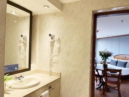 a bathroom with a sink and a mirror and a table at Hotel Bogotá Regency Usaquén in Bogotá