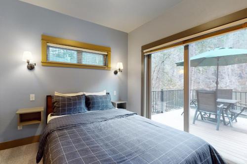 1 dormitorio con 1 cama y balcón con sombrilla en Osprey Nest Cabin, en Vida