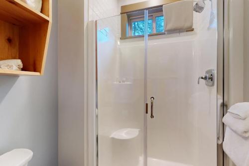 y baño con ducha y puerta de cristal. en Osprey Nest Cabin, en Vida