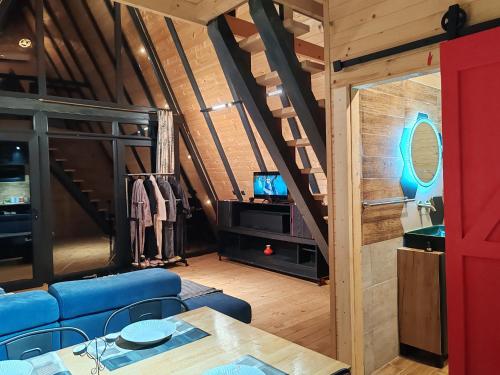 ein Wohnzimmer mit einem blauen Sofa und einem TV in der Unterkunft Mountain spa Yin&Yang in Ledinci