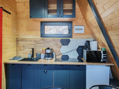 eine Küche mit blauen Schränken und einer Mikrowelle in der Unterkunft Mountain spa Yin&Yang in Ledinci