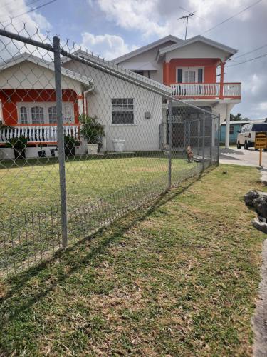 ein Zaun mit Kettenbindung vor einem Haus in der Unterkunft Joyville in Bridgetown