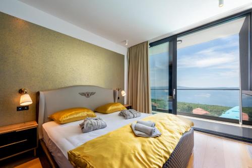a bedroom with a bed with yellow pillows and a large window at Villa HB Crikvenica in Crikvenica