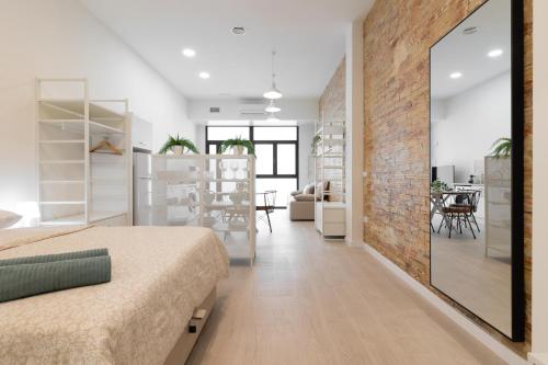 a bedroom with a bed and a brick wall at NEW BEACH flats VALENCIA in Valencia