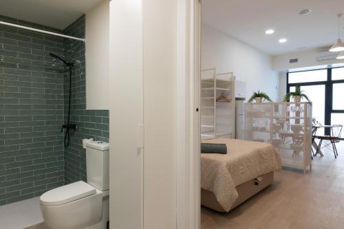 baño con cama, aseo y azulejos verdes en NEW BEACH flats VALENCIA en Valencia