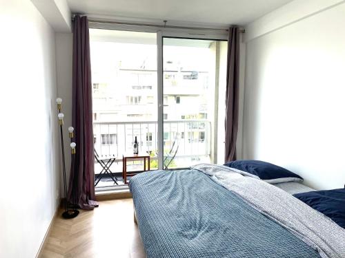 une chambre avec un lit et une grande fenêtre dans l'établissement Superb flat with iconic Eiffel tower view, à Paris