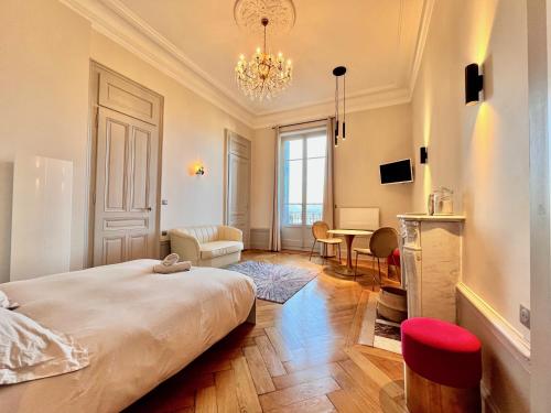 a bedroom with a large bed and a dining room at Appartement bourgeois avec terrasse et vue lac in Aix-les-Bains