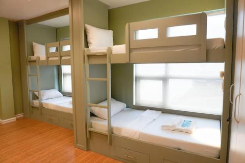 two bunk beds in a room with a window at ALTEAN Apartments - Lourdes Room in Manila
