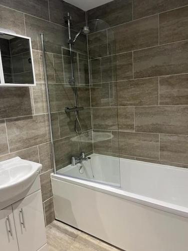 a bathroom with a shower and a tub and a sink at Albert House in Airdrie