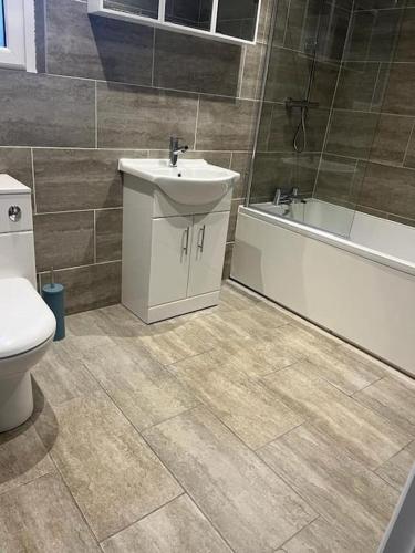 a bathroom with a sink and a toilet and a bath tub at Albert House in Airdrie