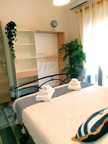 a bedroom with a bed with towels on it at Sa Terra Mea - Luxury Apartment in Torpè