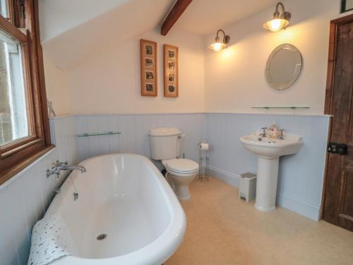 a bathroom with a tub and a toilet and a sink at Dale View in Whitby