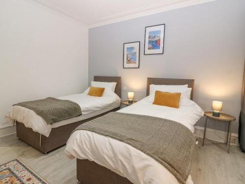 two beds in a small room with two lamps at 16 Main Street in Ellon