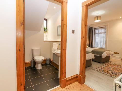 a bathroom with a toilet and a bed in a room at 16 Main Street in Ellon