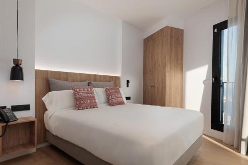 a bedroom with a large white bed and a telephone at Tembo Barcelona in Barcelona