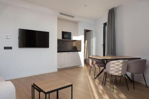 a living room with a table and chairs and a television at Tembo Barcelona in Barcelona