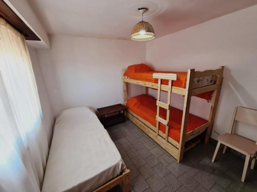 a small room with two bunk beds and a chair at Duplex 300 m del mar Barapoint in Necochea