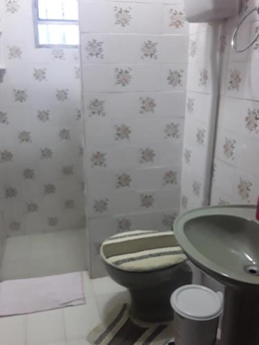 a bathroom with a green toilet and a sink at CASA COM PISCINA EM BALNEÁRIO PINHAL RS in Pinhal