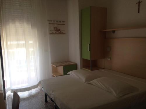 een slaapkamer met 2 bedden en een raam bij Hotel Lazzarini in Bellaria-Igea Marina