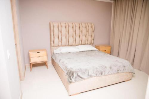 - une petite chambre avec un lit et une table de nuit dans l'établissement Aparta Suite en el BlueGarden, à Barranquilla