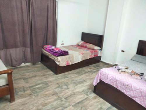 two twin beds in a room with a floor at Guest House Alam w in Marsa Alam City