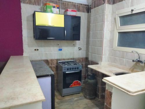 a kitchen with a stove and a tv on the wall at Guest House Alam w in Marsa Alam City
