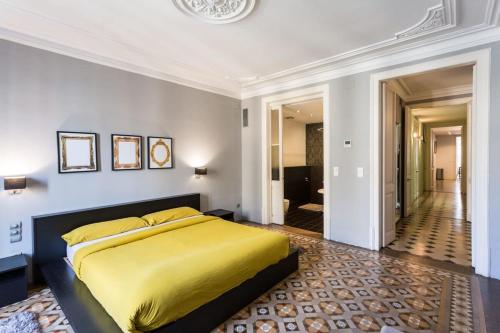 a bedroom with a yellow bed and a hallway at Ronda Sant Pere in Barcelona