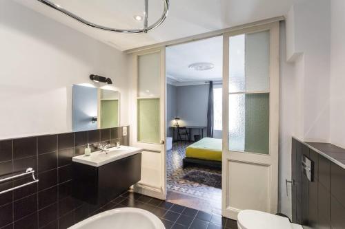 a bathroom with a sink and a toilet and a bed at Ronda Sant Pere in Barcelona
