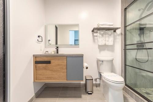 a bathroom with a toilet and a sink and a mirror at Hotel Koxie in Los Angeles