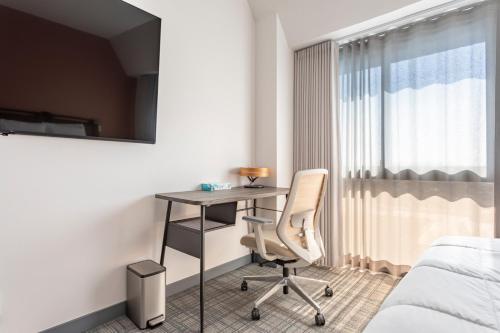 a bedroom with a desk and a bed and a chair at Hotel Koxie in Los Angeles