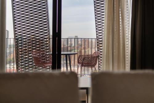 a balcony with chairs and a table and a window at Tembo Barcelona in Barcelona