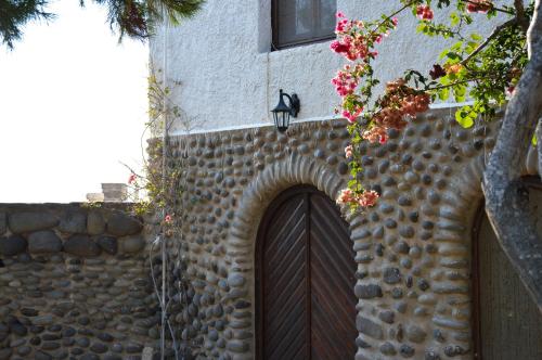 un edificio con una puerta de madera y una pared de piedra en The Lady of Flakopi, en Pachaina