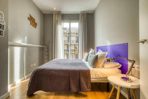 sypialnia z dużym łóżkiem z fioletowym zagłówkiem w obiekcie Perfectly located 4-bed 4-bath apartment in Barcelona 2-1 w Barcelonie