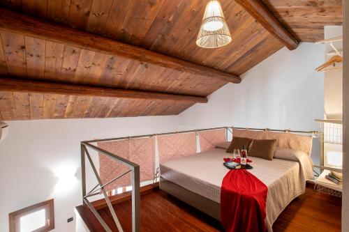 a bedroom with a bed in a room with wooden ceilings at Sa Domo Apartments in Alghero