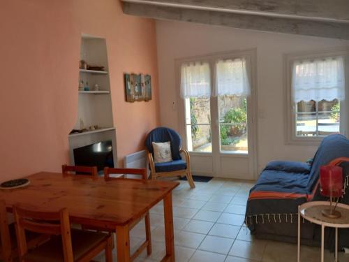 un salon avec une table et des chaises en bois dans l'établissement Maison spacieuse Château d'Oléron, au Château-dʼOléron