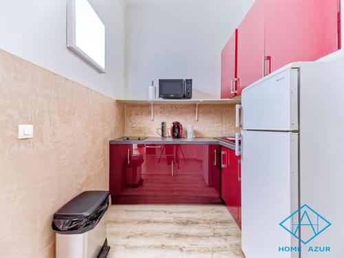 une cuisine avec des armoires rouges et un réfrigérateur blanc dans l'établissement Sookies Nice , Hyper Central+AirConditioner, à Nice