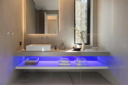 uma casa de banho com uma banheira azul e um lavatório. em Euphonia Residence by Athina Hospitality em Porto Heli